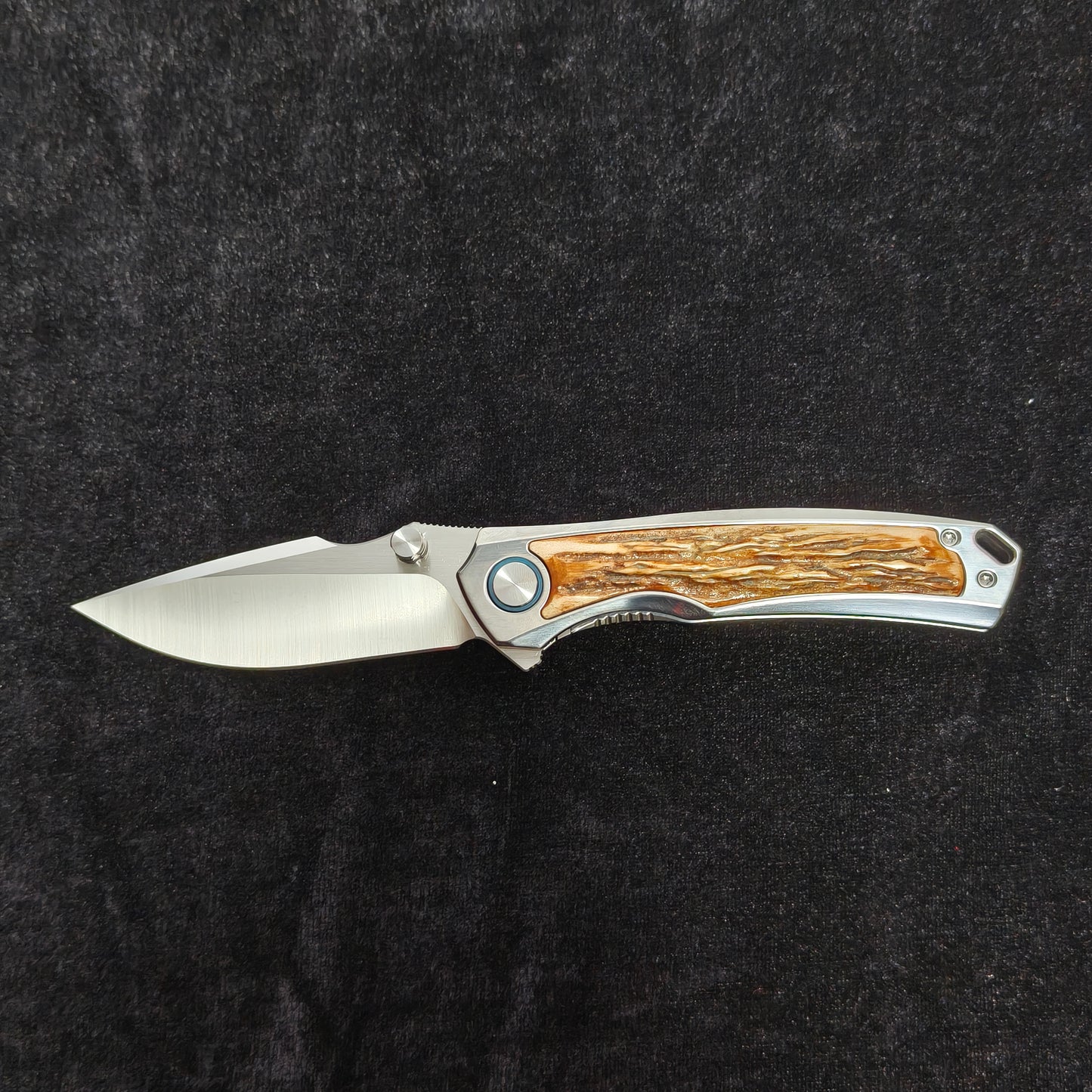 VORIXN AURON folding knife open horizontally, titanium handle with natural stag inlay detail