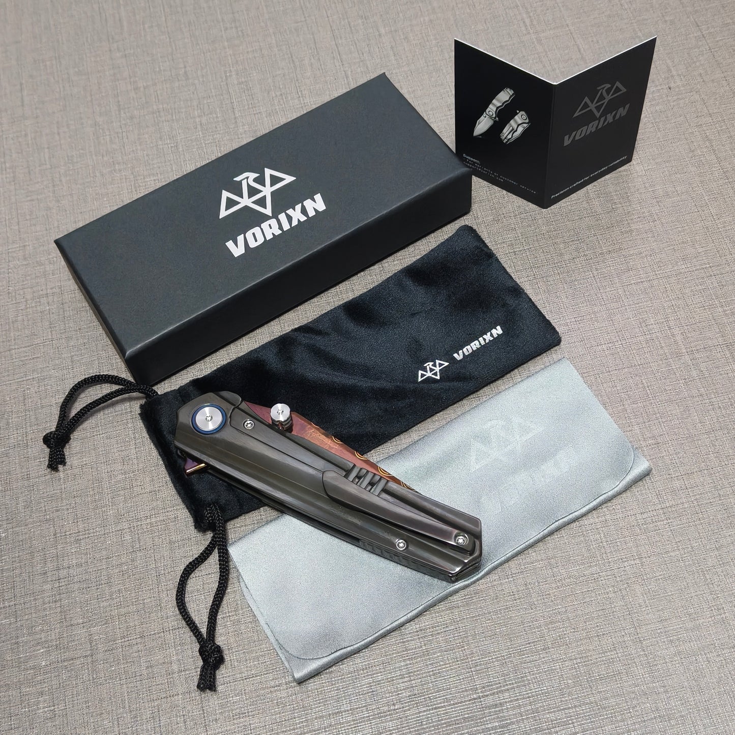 VORIXN folding knife packaging contents including a soft drawstring pouch, a care and usage instruction card, and a microfiber cleaning cloth