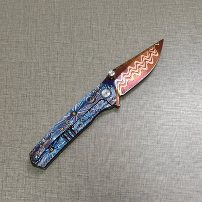 Impact Origin titanium folding knife open, clip side view with hand-flame Damascus blade angled upward