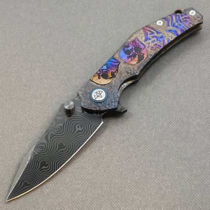 VORIXN Skull Rift KB128 Folding Knife – open non-clip side view showing titanium-engraved anodized handle and Damascus blade profile