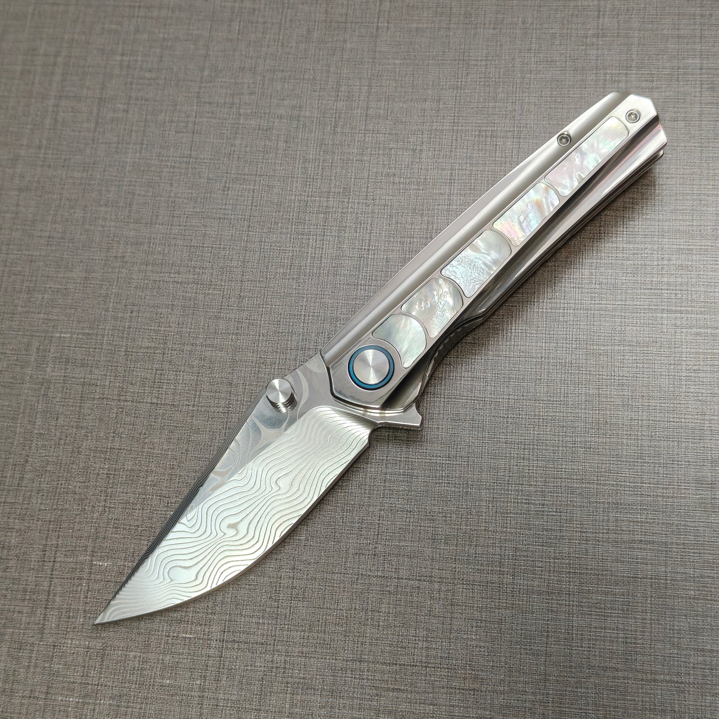 VORIXN Ocean Mirage folding knife open, non-clip side, Damascus blade angled 45 degrees downward