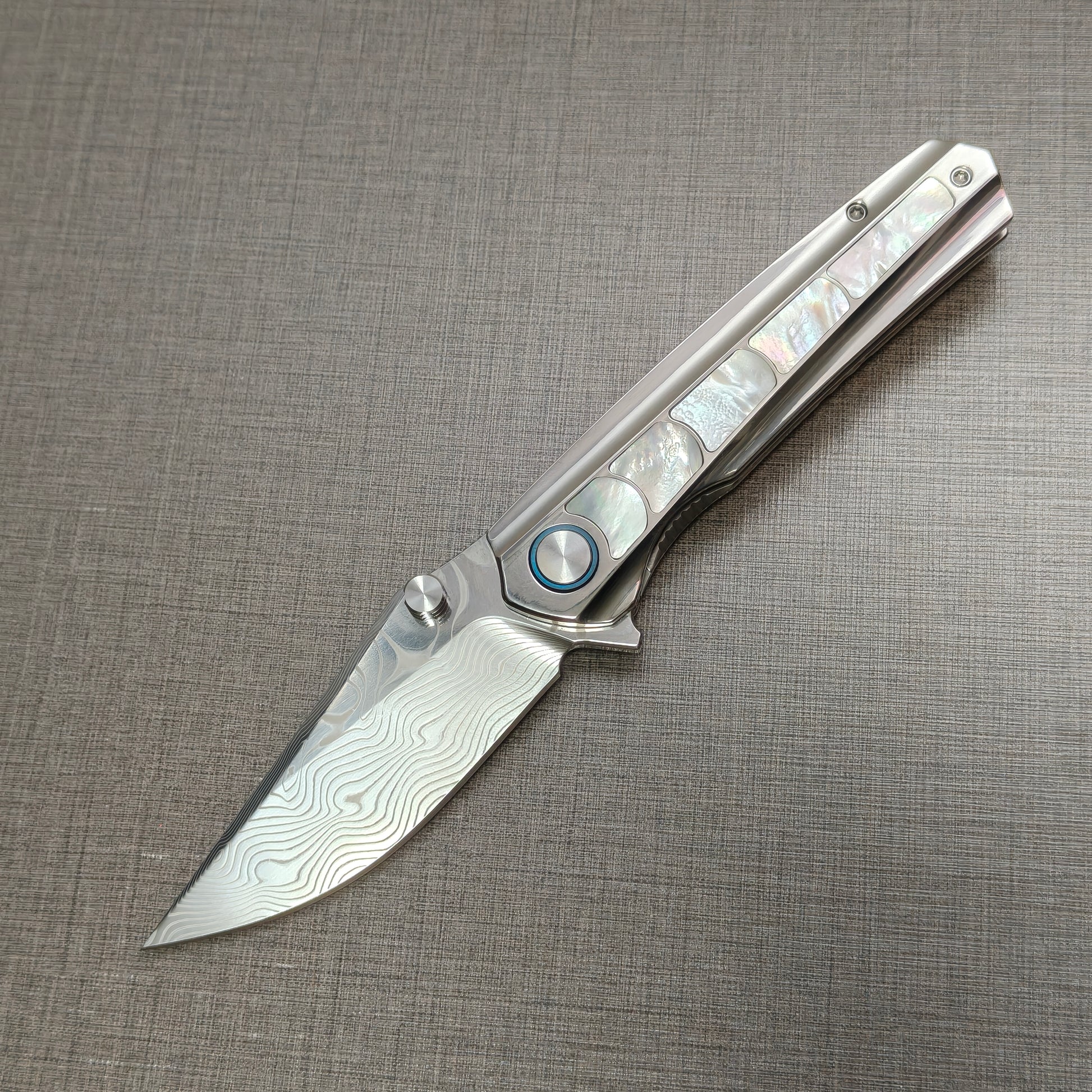 VORIXN Ocean Mirage folding knife open, non-clip side, Damascus blade angled 45 degrees downward