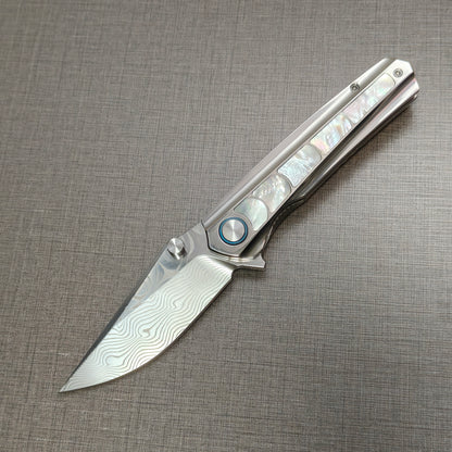 VORIXN Ocean Mirage folding knife open, non-clip side, Damascus blade angled 45 degrees downward