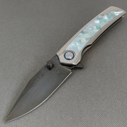 VORIXN KB104 Ocean Mirage Folding Knife – open non-clip side view showing White Mother-of-Pearl Inlaid Titanium handle and DLC-coated Damascus blade profile