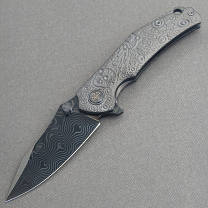 VORIXN Prism KB129 Folding Knife – open non-clip side view showing hand-engraved anodized titanium handle and Damascus blade profile
