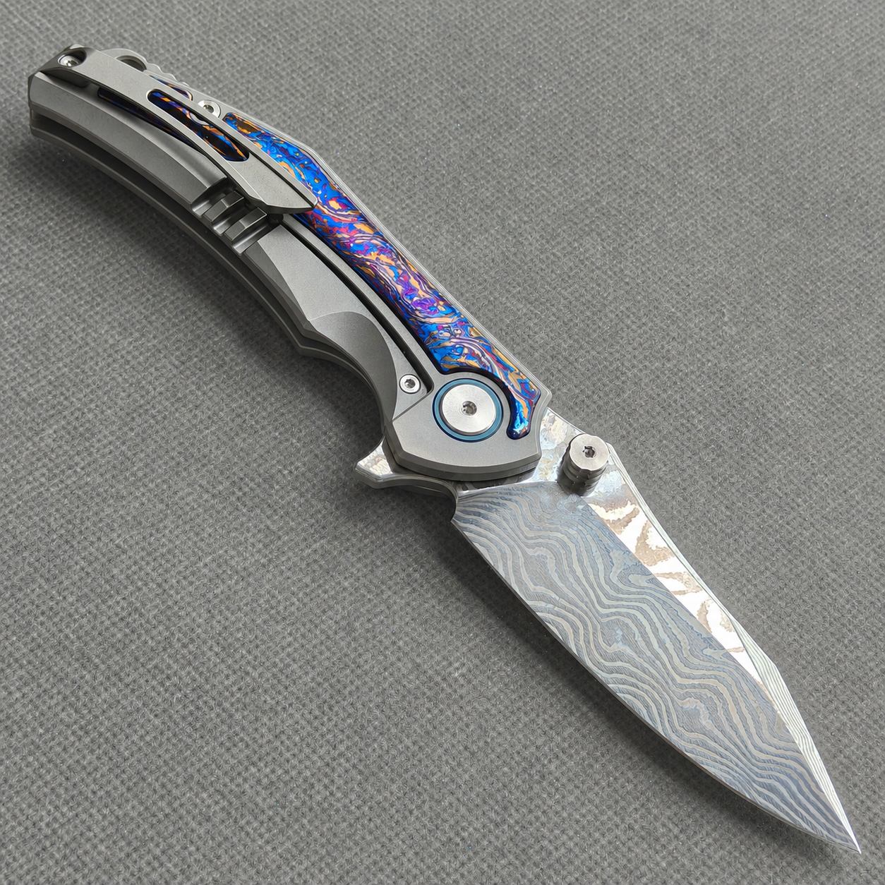 VORIXN KB031 open clip-side view showing pocket clip, hand-flamed zirconium inlay titanium handle, and overall profile.
