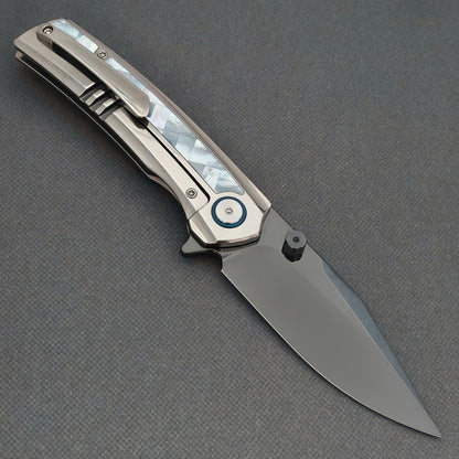 VORIXN Ocean Mirage KB093 folding knife, open pocket clip side showing a dark blade, white handle inlay and blue pivot ring.