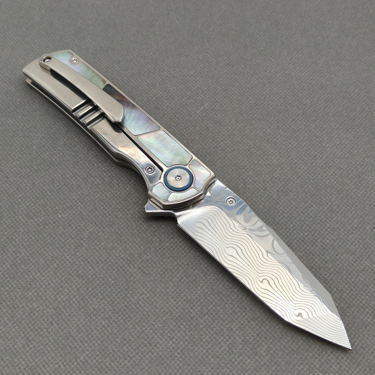 VORIXN KB059 open clip-side view showing pocket clip, black mother-of-pearl inlaid titanium handle, and overall profile.