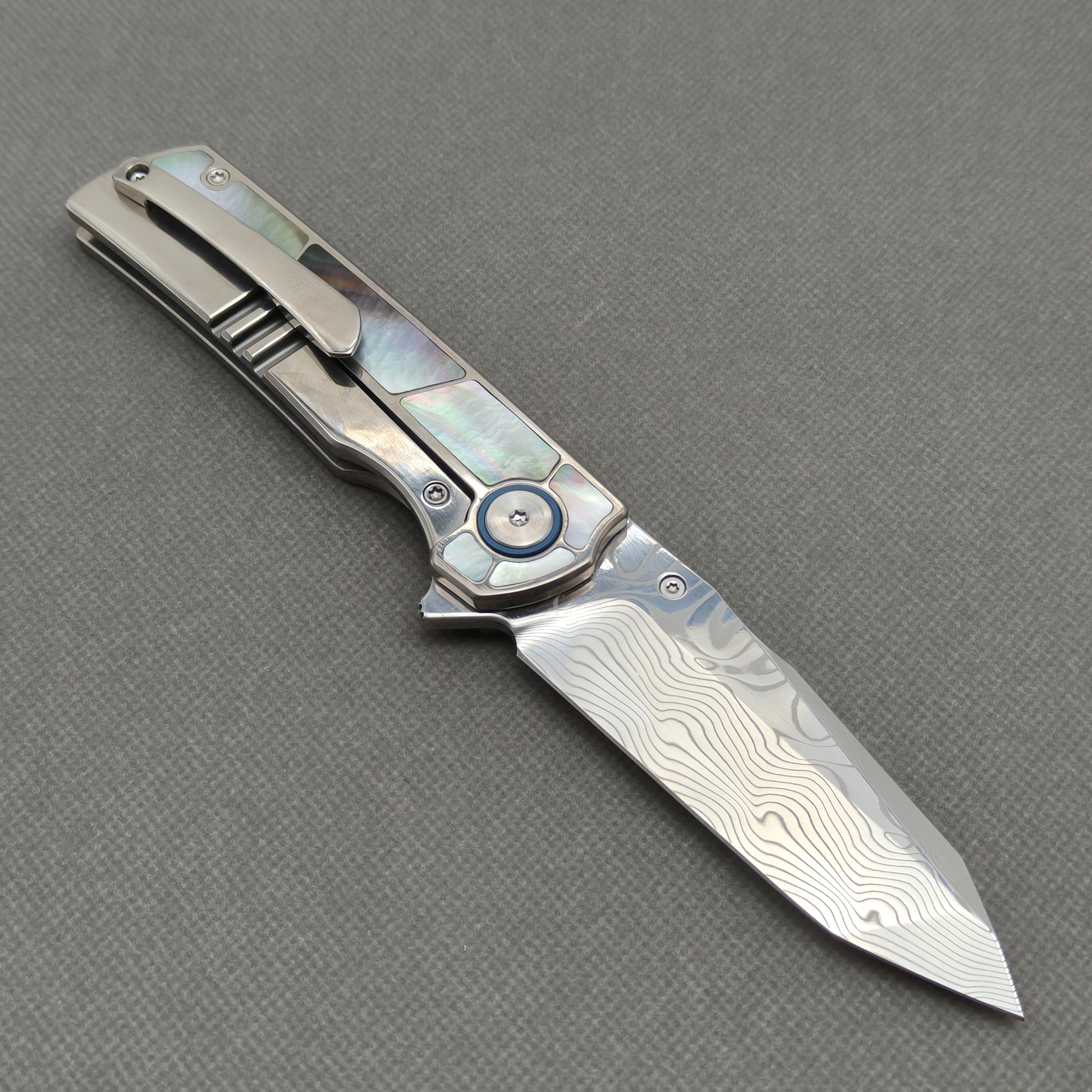 VORIXN KB059 open clip-side view showing pocket clip, black mother-of-pearl inlaid titanium handle, and overall profile.