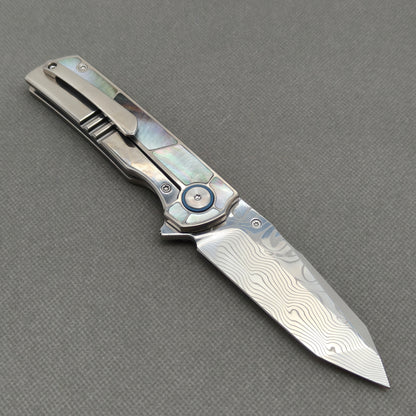 VORIXN KB059 open clip-side view showing pocket clip, black mother-of-pearl inlaid titanium handle, and overall profile.