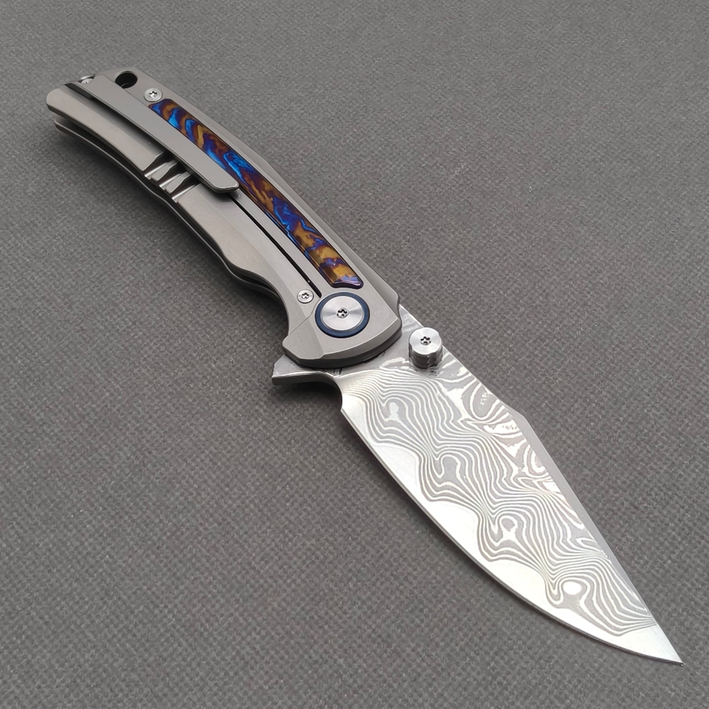 VORIXN KB019 open clip-side view showing pocket clip, hand-flamed zirconium inlay titanium handle, and overall profile.