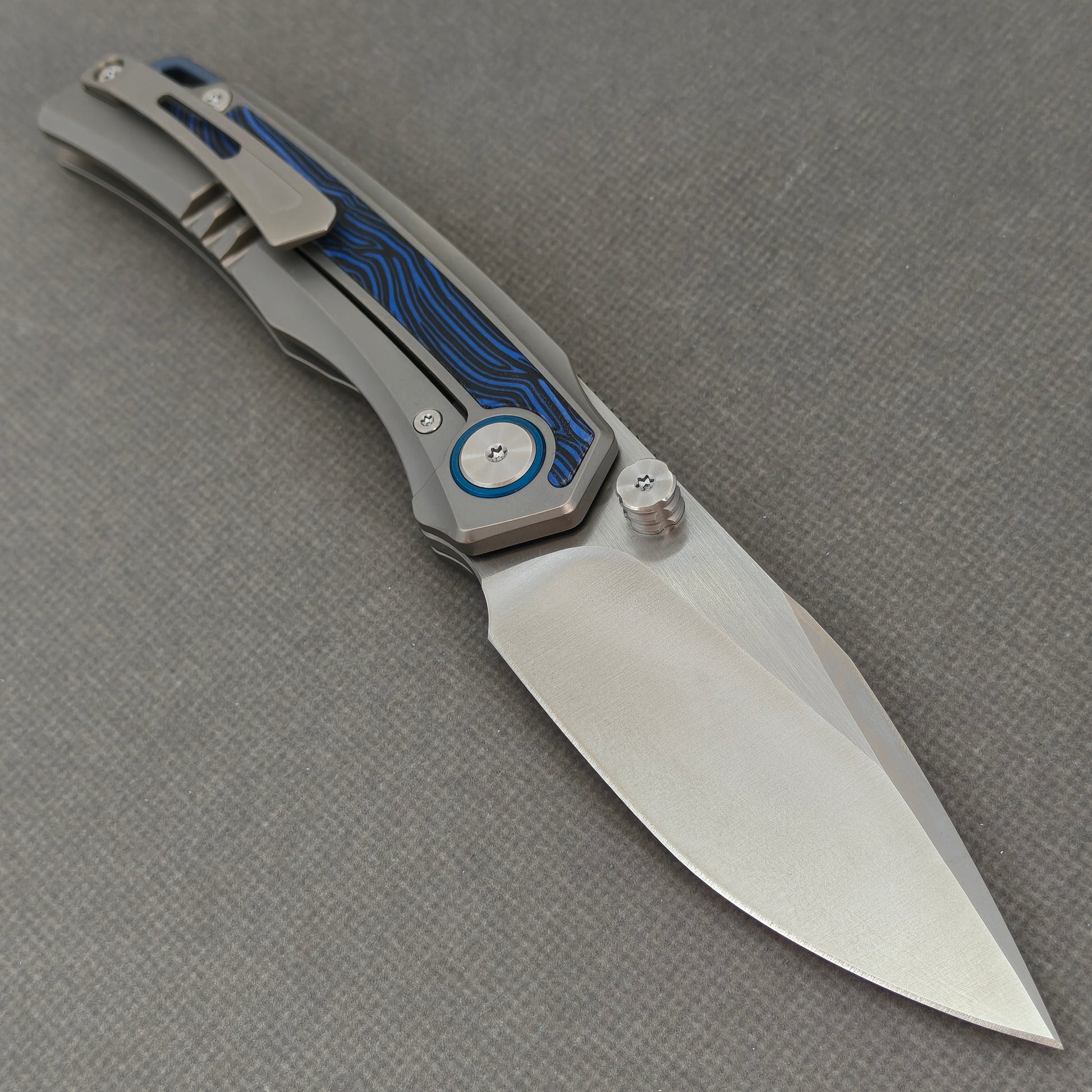 VORIXN KB005 open clip-side view showing pocket clip, bead-blasted titanium and G10 handle, and overall profile.