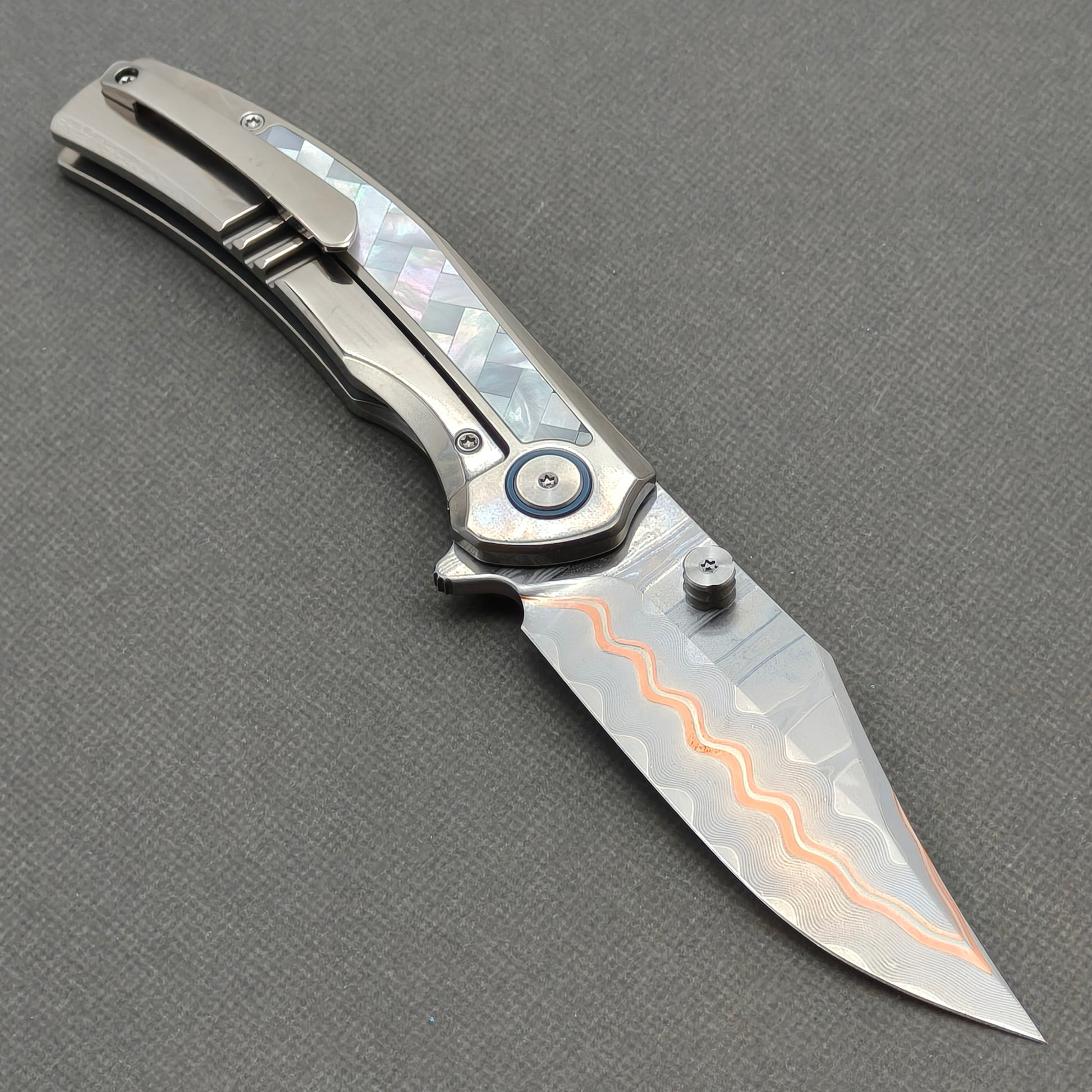 VORIXN KB068 open clip-side view showing pocket clip, white mother-of-pearl inlaid titanium handle, and overall profile.