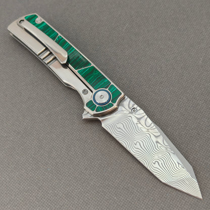 VORIXN KB062 open clip-side view showing pocket clip, malachite inlaid titanium handle, and overall profile.