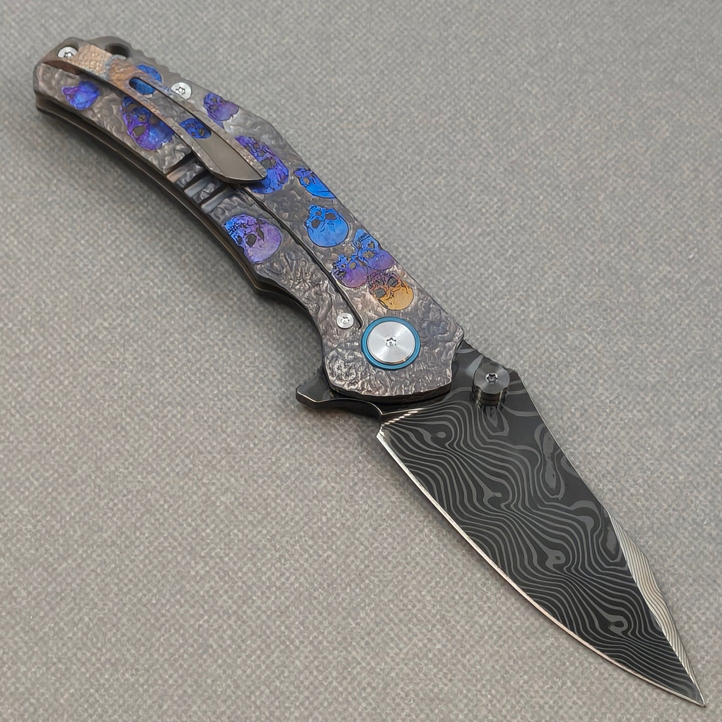 VORIXN Skull Rift KB128 Folding Knife – open clip side view showing pocket clip and titanium-engraved anodized handle