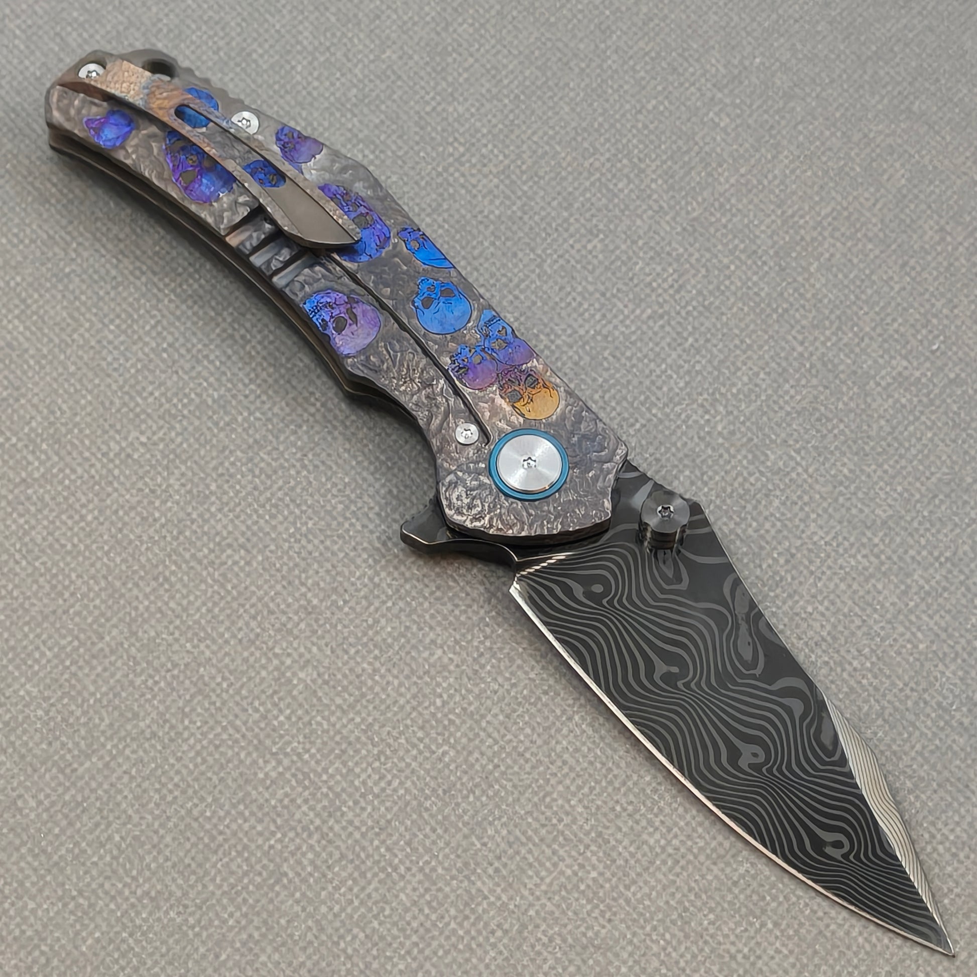 VORIXN Skull Rift KB128 Folding Knife – open clip side view showing pocket clip and titanium-engraved anodized handle