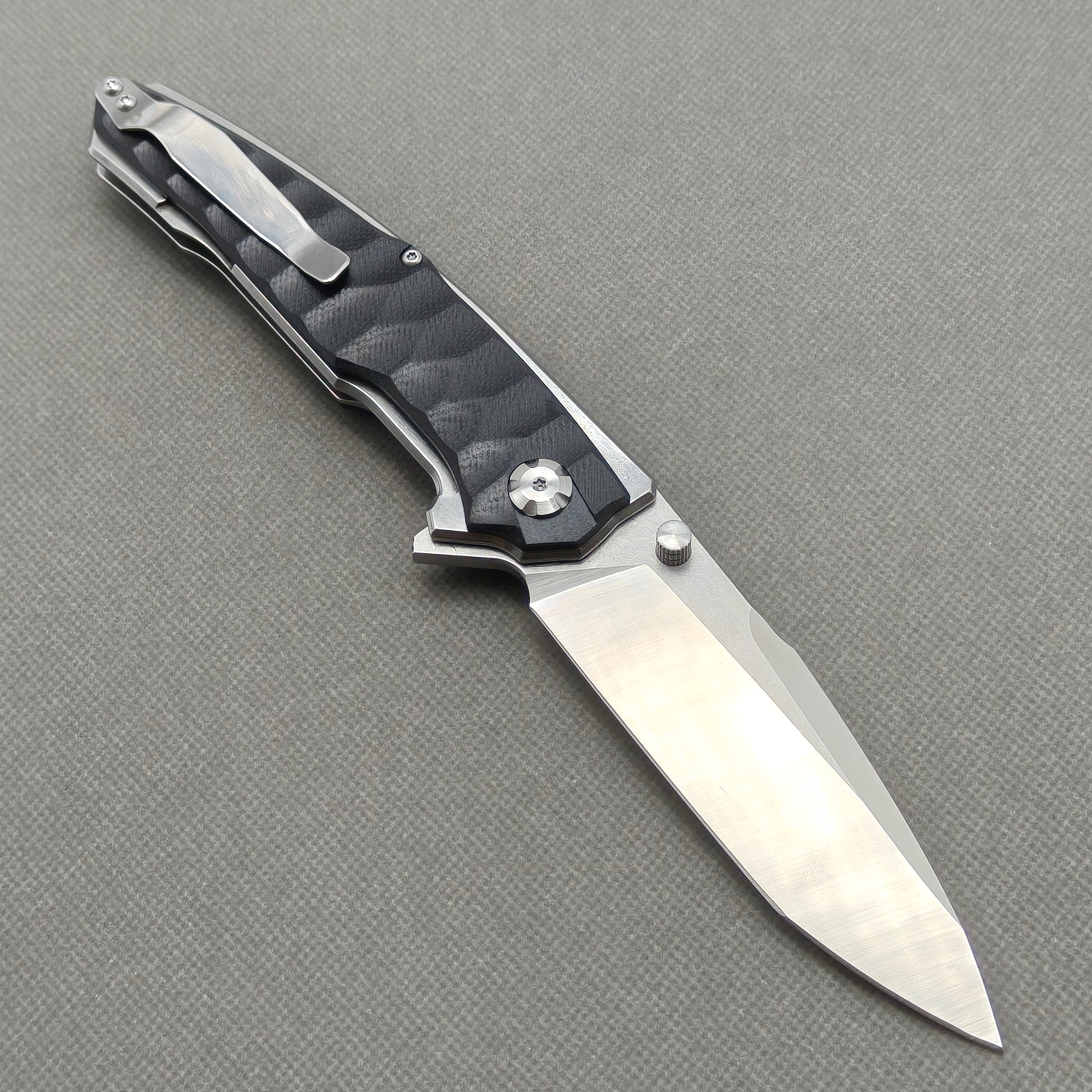 VORIXN KA009 open clip-side view showing pocket clip, black G10 handle, and overall profile.