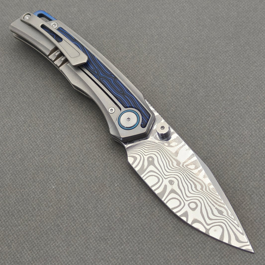 VORIXN Tidecipher KB157 Folding Knife – open clip side view showing Damascus blade, pocket clip, and blue handle inlay.