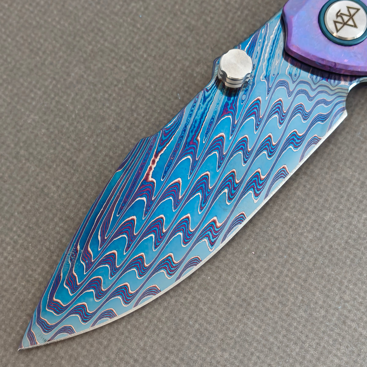 VORIXN Rimeforge KB125 Folding Knife – blade detail showing Damascus steel pattern and edge.