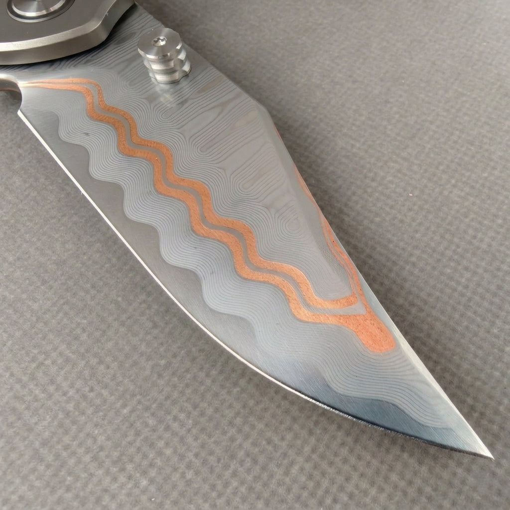 VORIXN KB074 clip-side blade detail showing the Cu-Mai blade pattern.