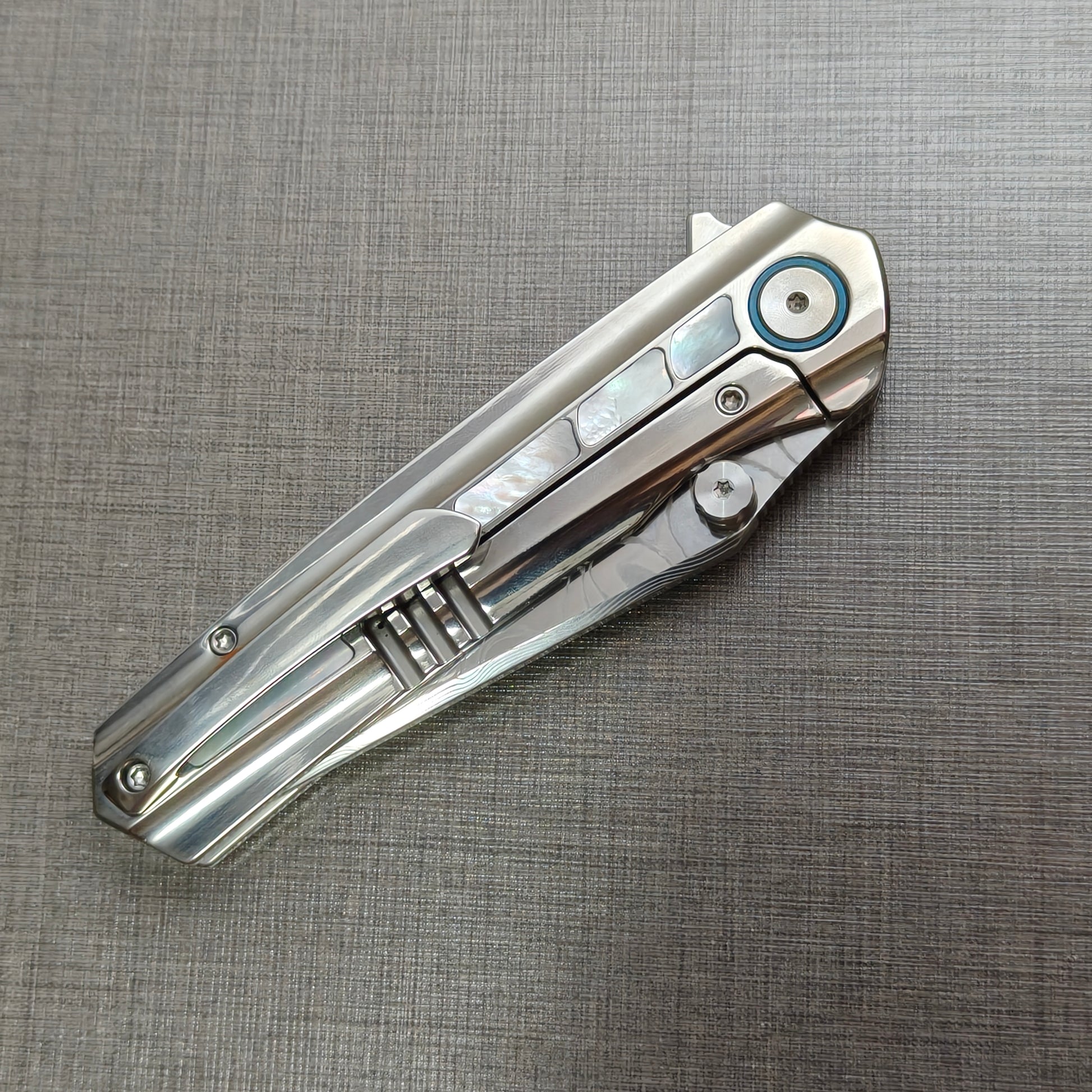 VORIXN Ocean Mirage folding knife closed, pocket clip side, full view of titanium handle and clip design