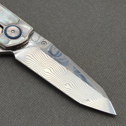 VORIXN KB059 clip-side blade detail showing the Damascus blade pattern.