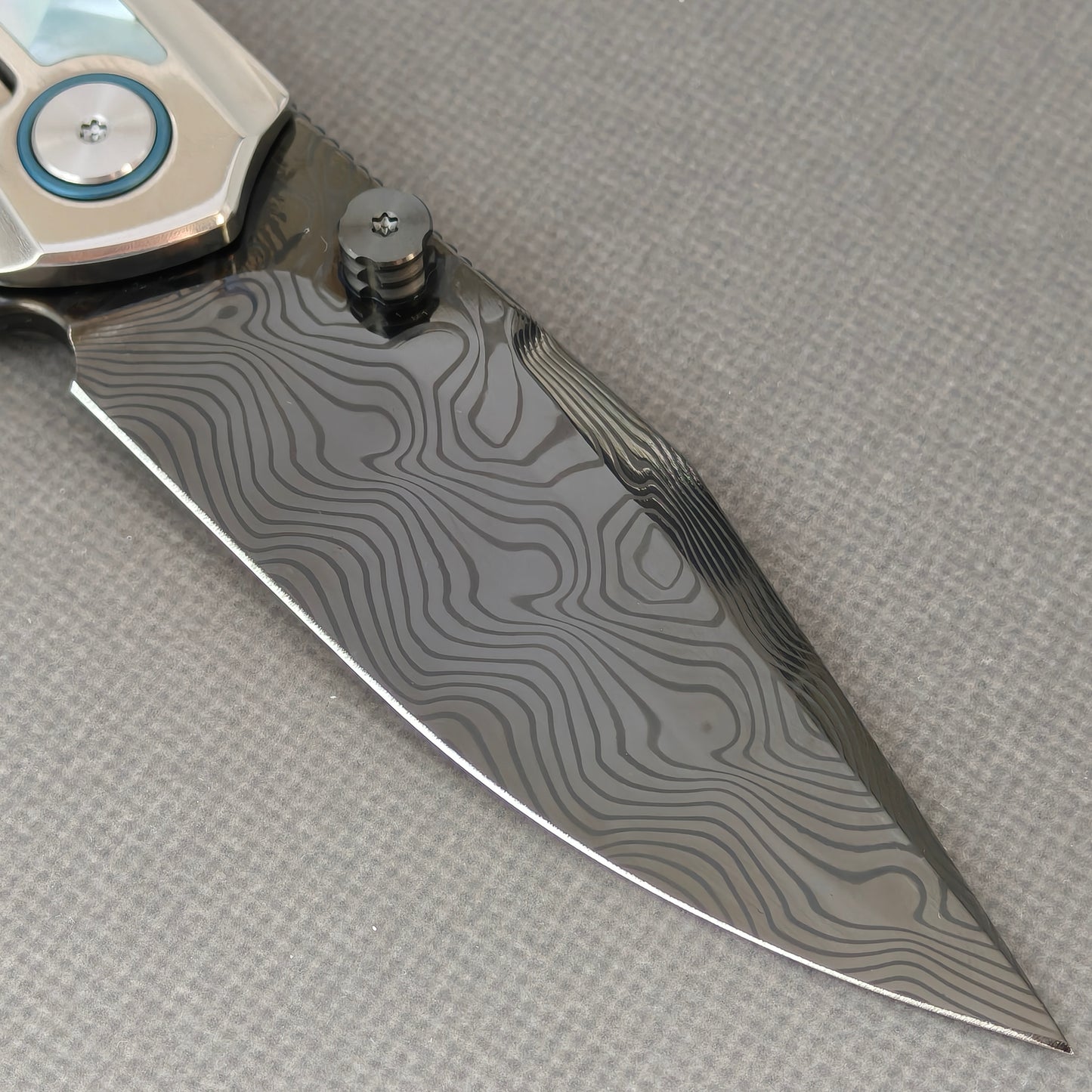 VORIXN KB104 Ocean Mirage Folding Knife – clip side blade detail showing Damascus steel and Mother-of-Pearl handle junction