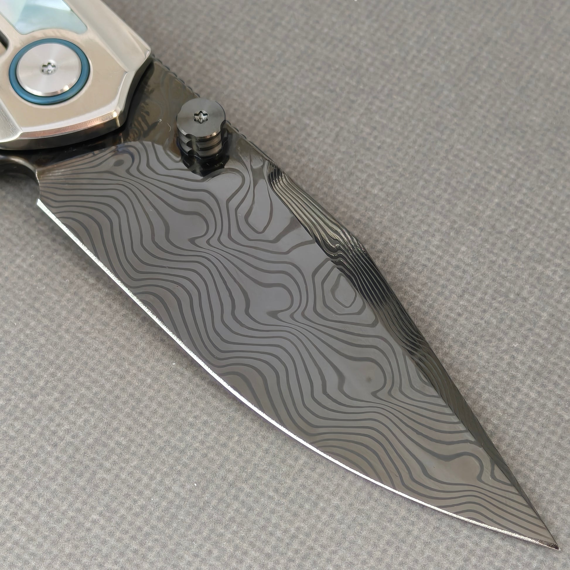 VORIXN KB104 Ocean Mirage Folding Knife – clip side blade detail showing Damascus steel and Mother-of-Pearl handle junction