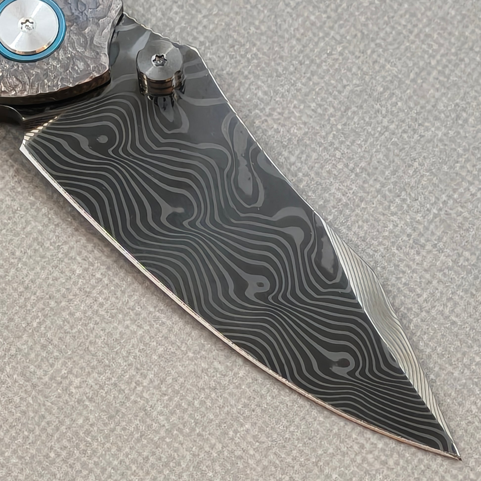 VORIXN Skull Rift KB128 Folding Knife – clip side blade detail showing Damascus steel and handle junction