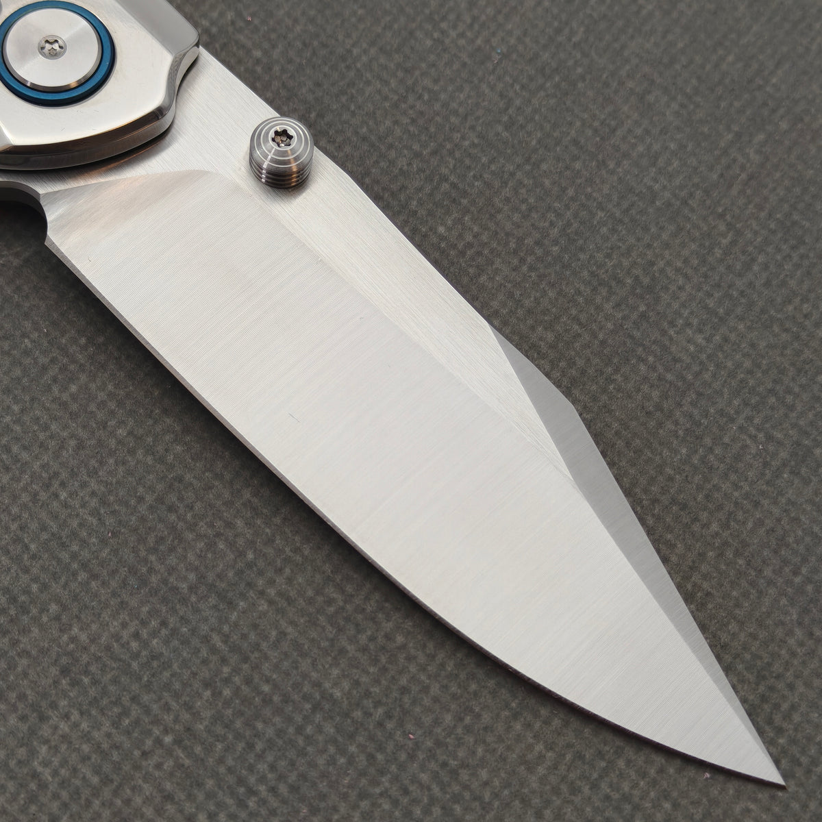 Reverse-side close-up of the VORIXN Pearlglint KB159 blade, grooved thumb stud and blue pivot ring.