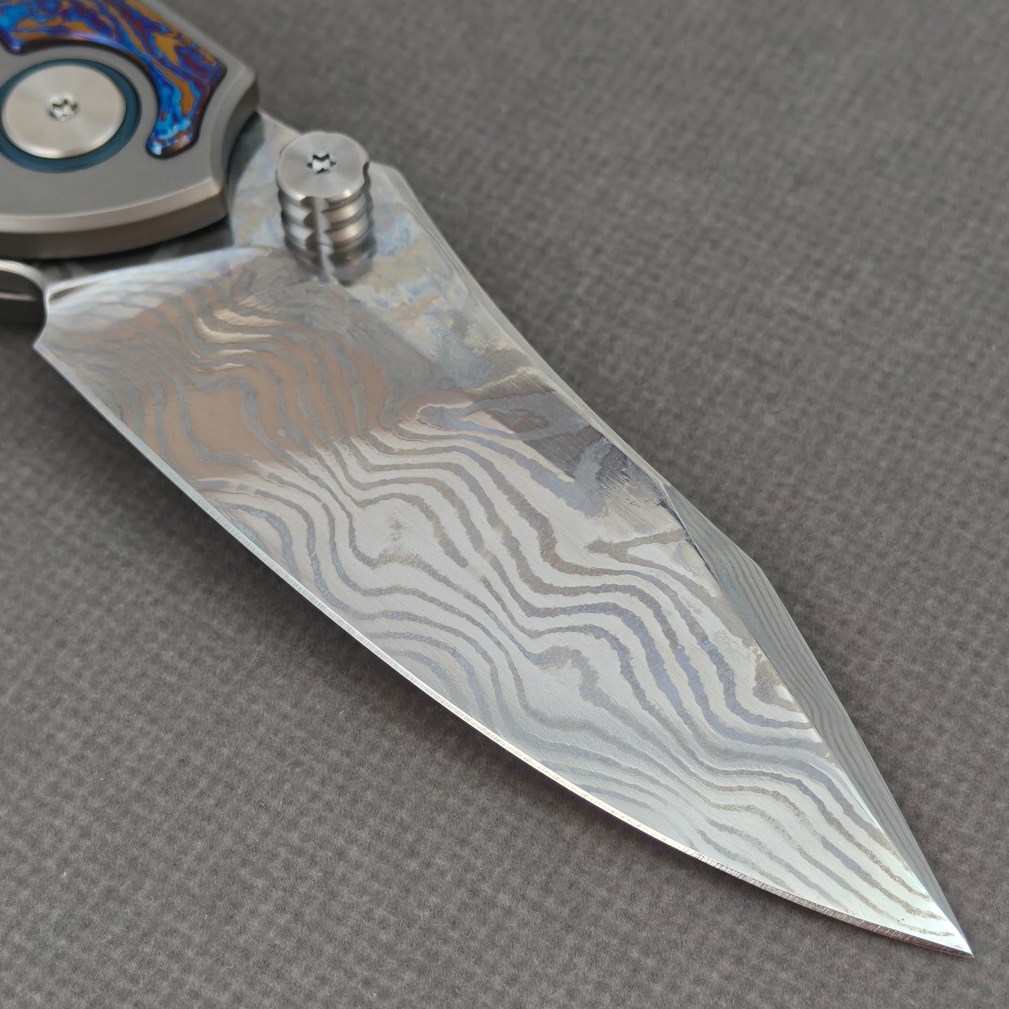 VORIXN KB031 clip-side blade detail showing the Damascus blade pattern.