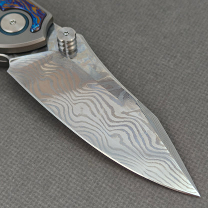 VORIXN KB031 clip-side blade detail showing the Damascus blade pattern.