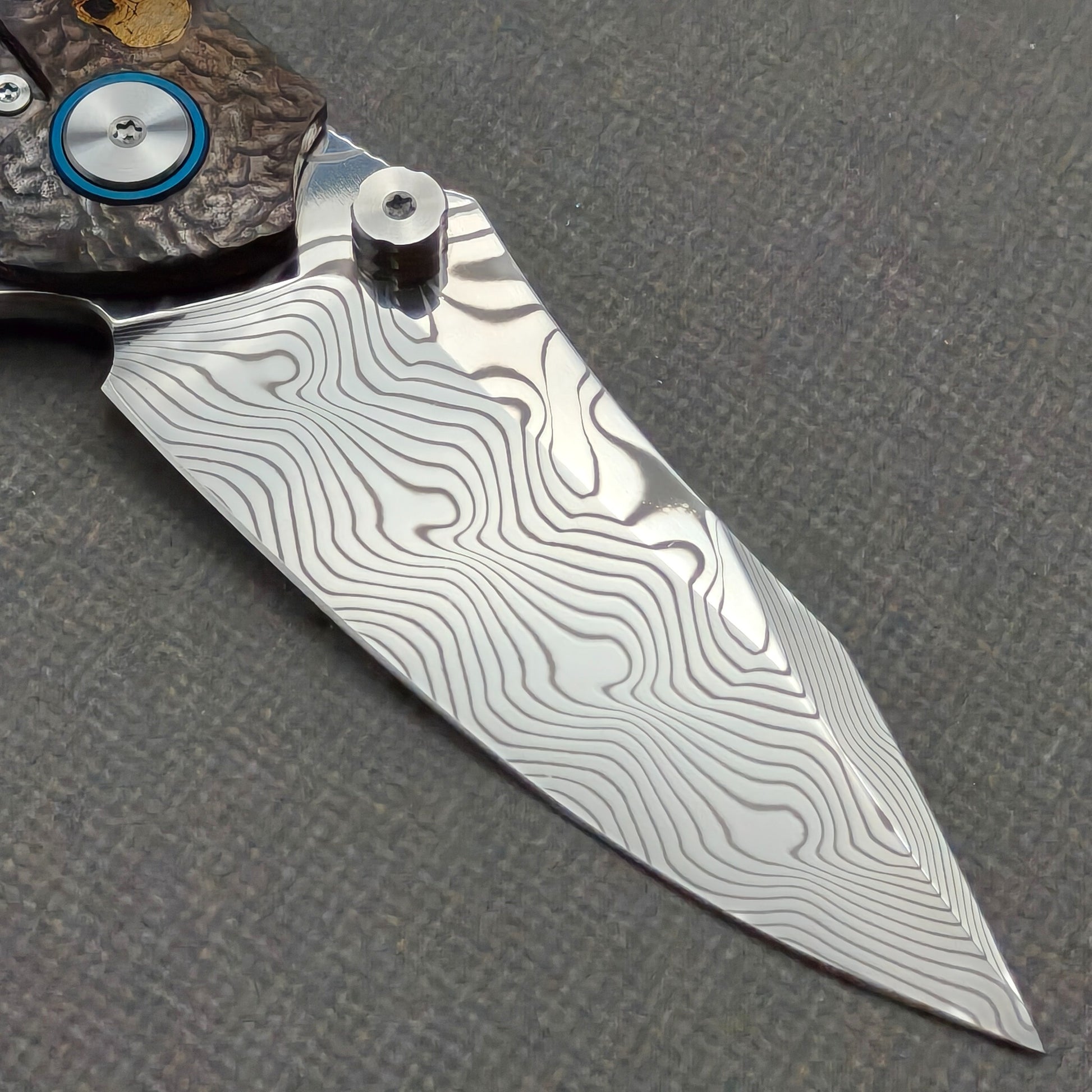 VORIXN KB096 clip-side blade detail showing the Damascus blade pattern.