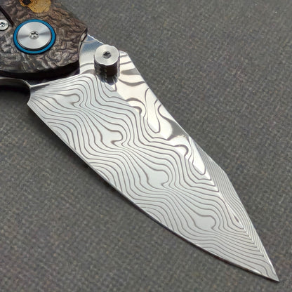 VORIXN KB096 clip-side blade detail showing the Damascus blade pattern.