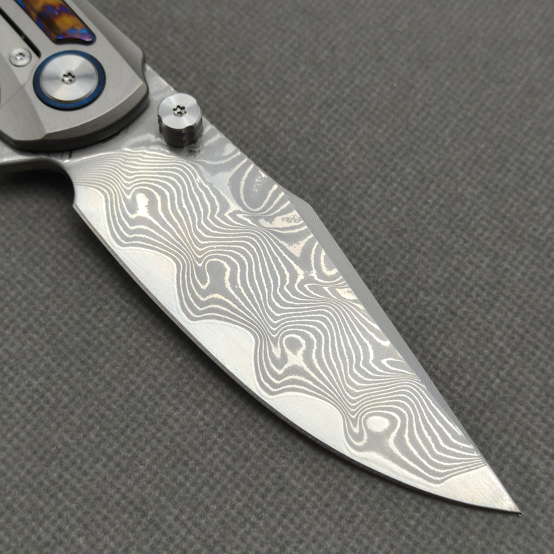 VORIXN KB019 clip-side blade detail showing the Damascus blade pattern.