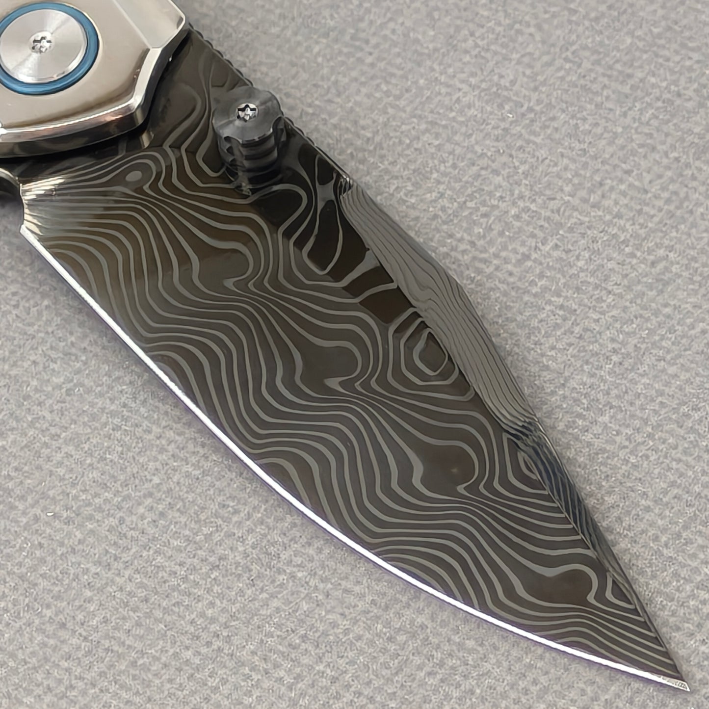 VORIXN Ocean Mirage KB104 Folding Knife – clip side blade detail showing Damascus DLC-Coated steel and handle junction