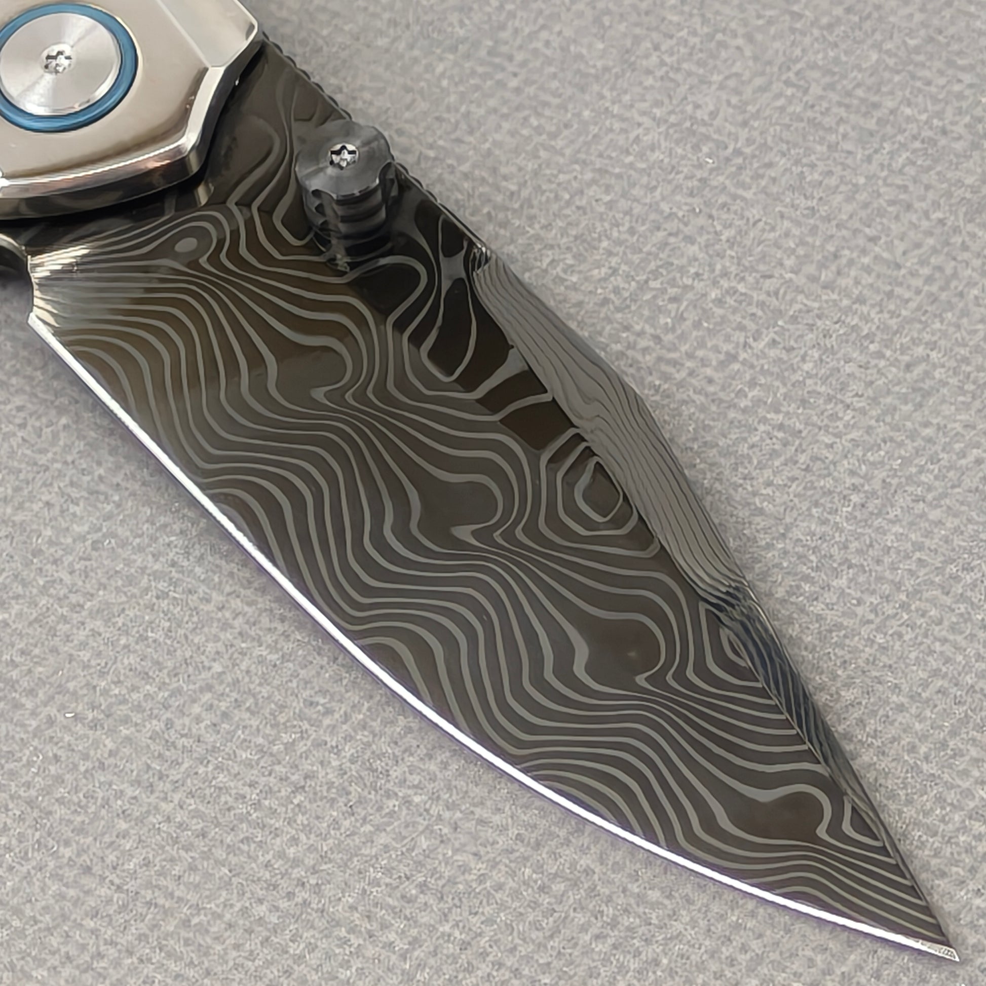 VORIXN Ocean Mirage KB104 Folding Knife – clip side blade detail showing Damascus DLC-Coated steel and handle junction