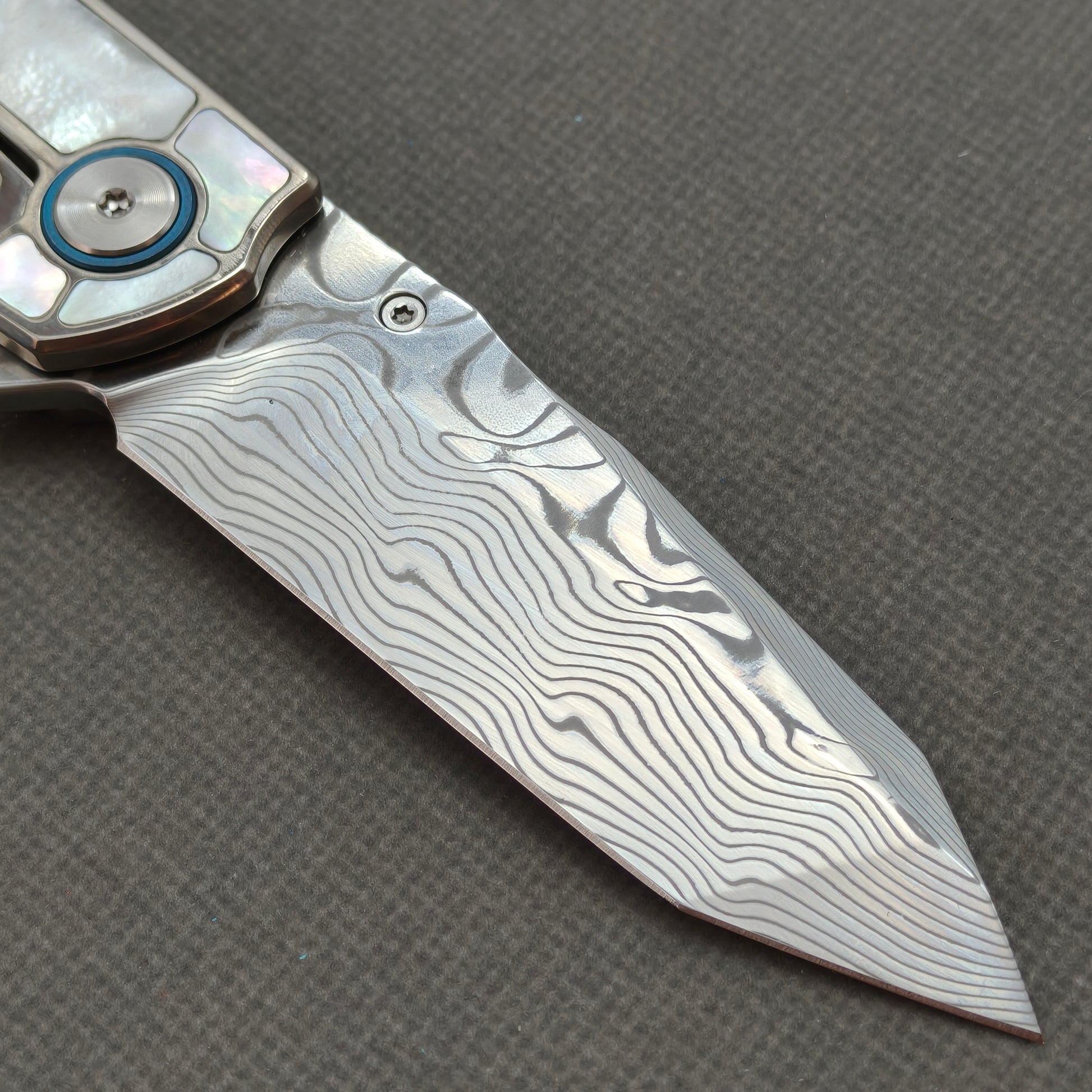 VORIXN KB063 clip-side blade detail showing the Damascus blade pattern.