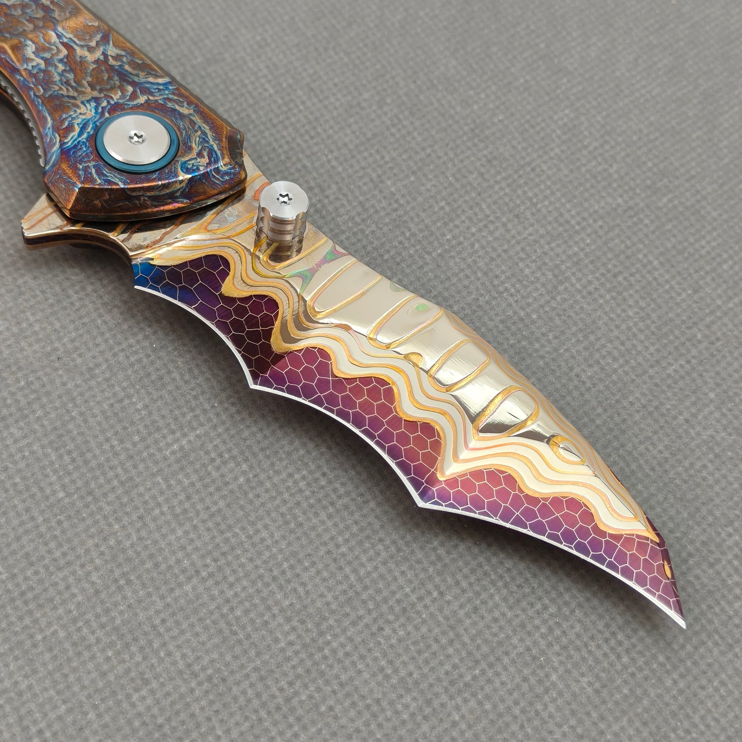 VORIXN KB057 clip-side blade detail showing the Copper San Mai Dragon Scale Damascus blade pattern.