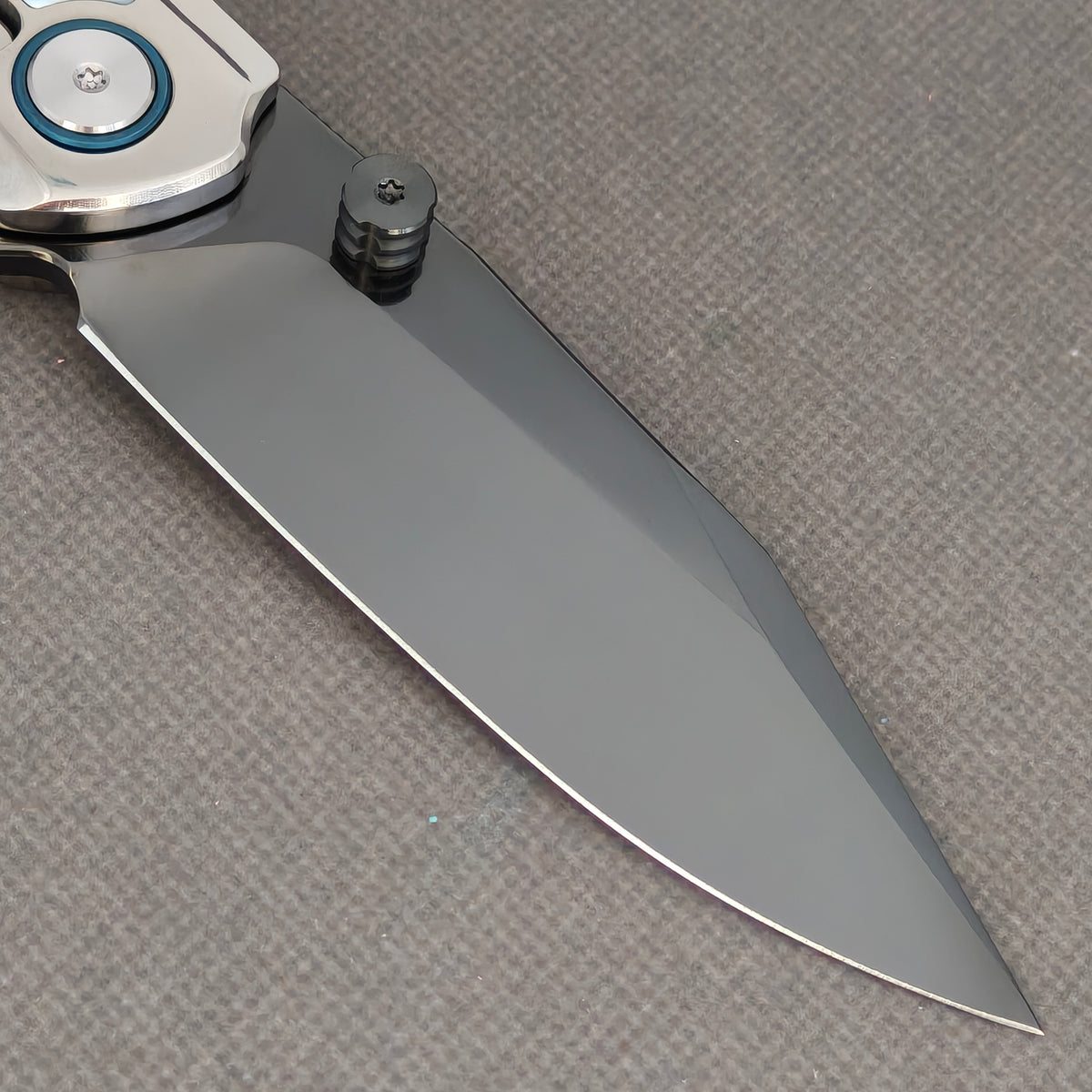 VORIXN Pearlcrest KB158 Folding Knife – clip-side blade detail showing dark blade, thumb stud, and blue pivot collar.