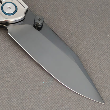 VORIXN Pearlcrest KB158 Folding Knife – clip-side blade detail showing dark blade, thumb stud, and blue pivot collar.