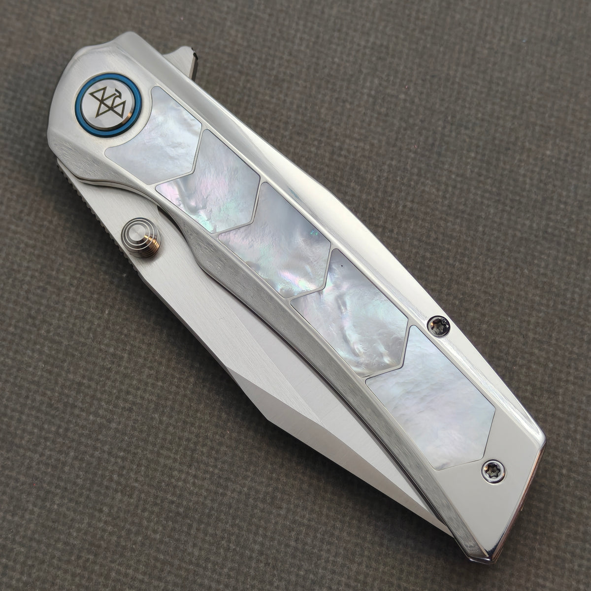 VORIXN Pearlglint KB159 folding knife, closed view showing iridescent white geometric handle inlays and a blue pivot ring.