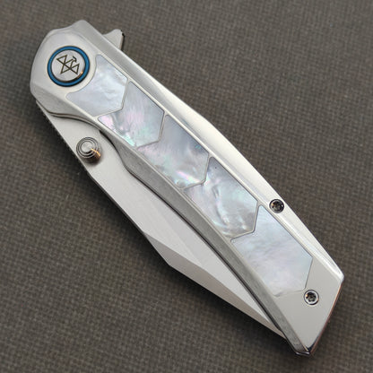 VORIXN Pearlglint KB159 folding knife, closed view showing iridescent white geometric handle inlays and a blue pivot ring.