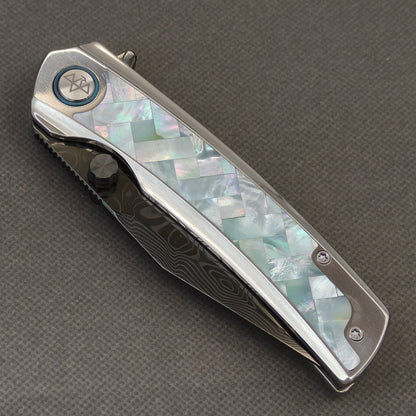 VORIXN Ocean Mirage KB104 Folding Knife – closed non-clip side view showing White Mother-of-Pearl Inlaid Titanium handle design and pivot