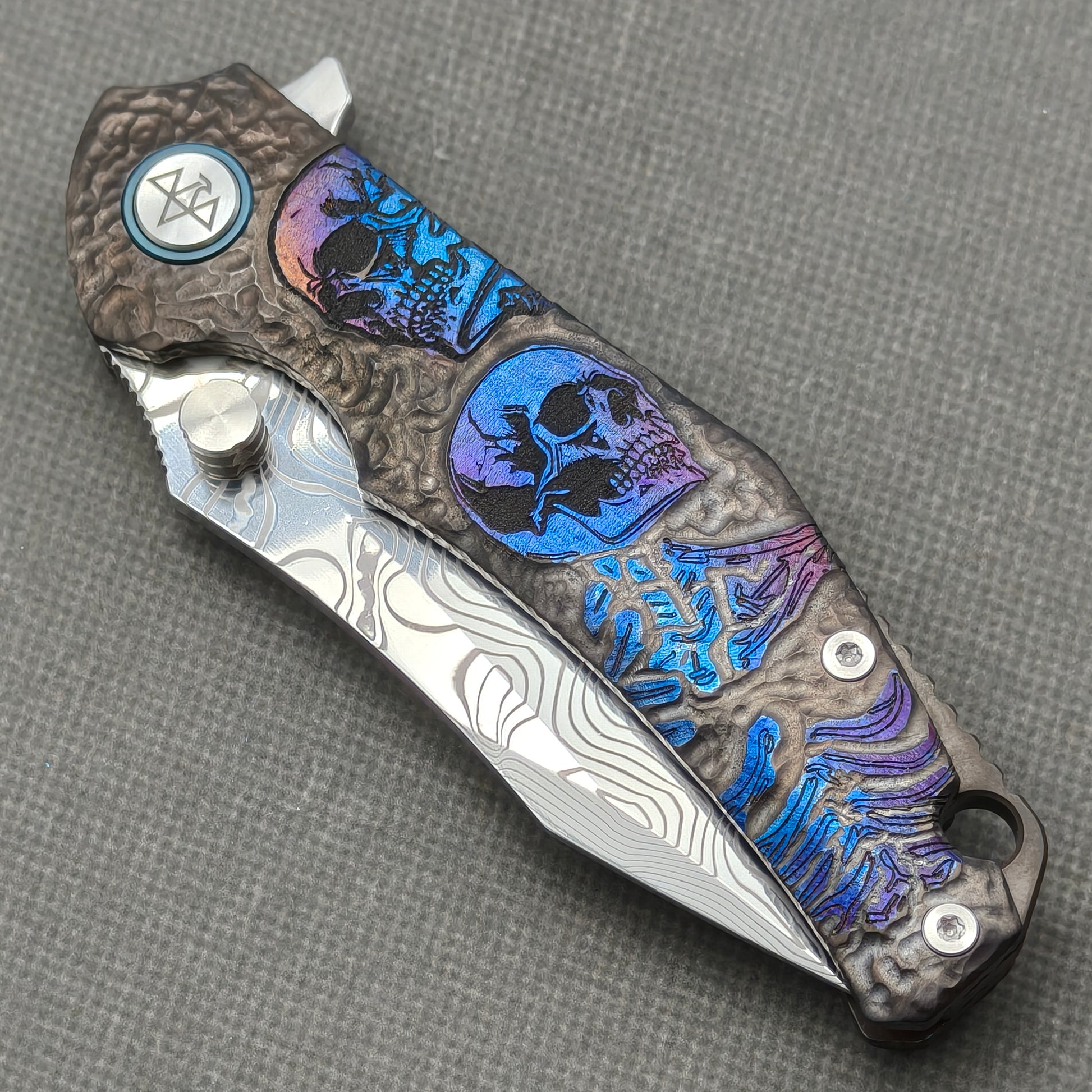 VORIXN KB096 closed non-clip side view showing skull-engraved anodized titanium handle design and pivot detail.