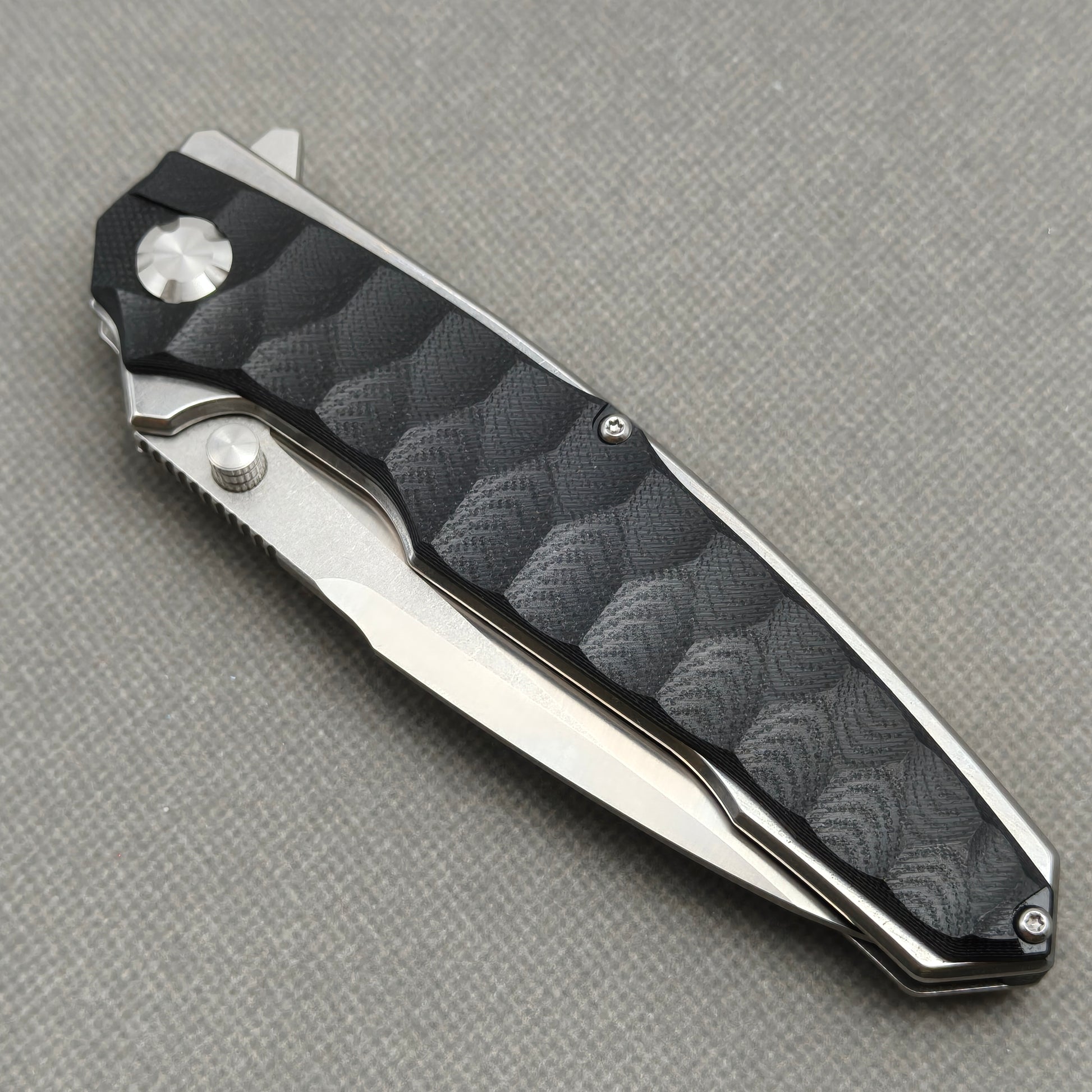 VORIXN KA009 closed non-clip side view showing black G10 handle design and pivot detail.