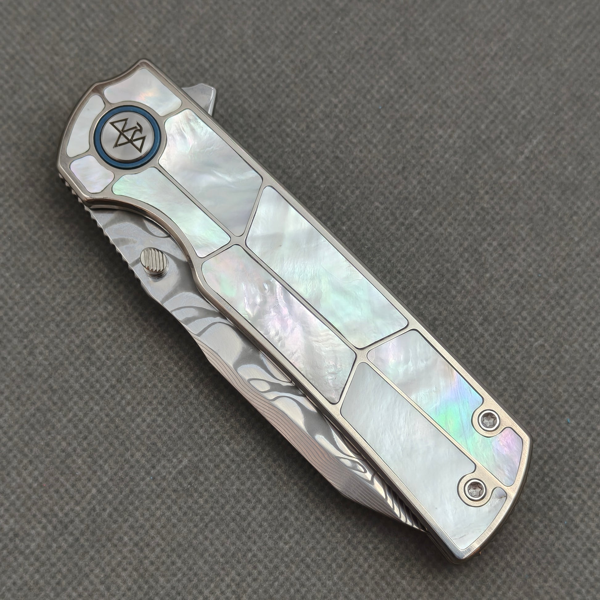 VORIXN KB063 closed non-clip side view showing white pearl inlaid titanium handle design and pivot detail.