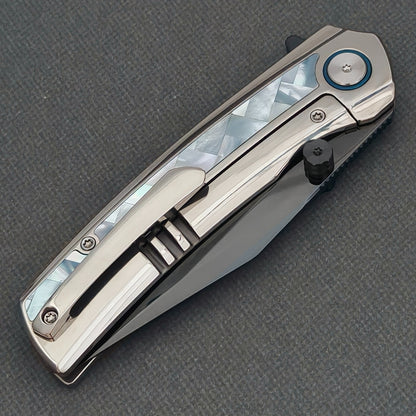 VORIXN Ocean Mirage KB093 folding knife, closed pocket clip side with white patterned inlay and a silver-tone clip.