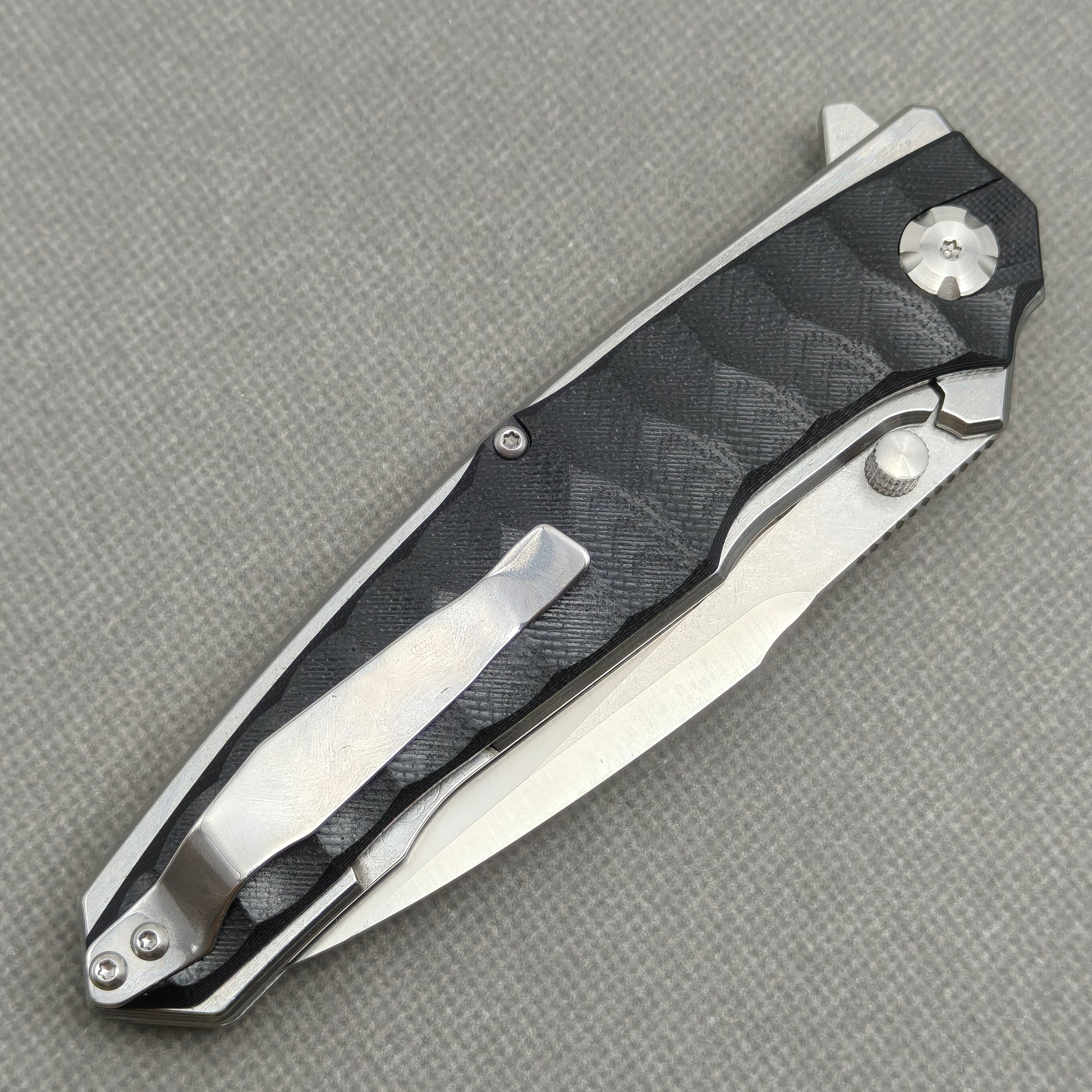 VORIXN KA009 closed clip-side view with pocket clip, screws, and black G10 handle back.