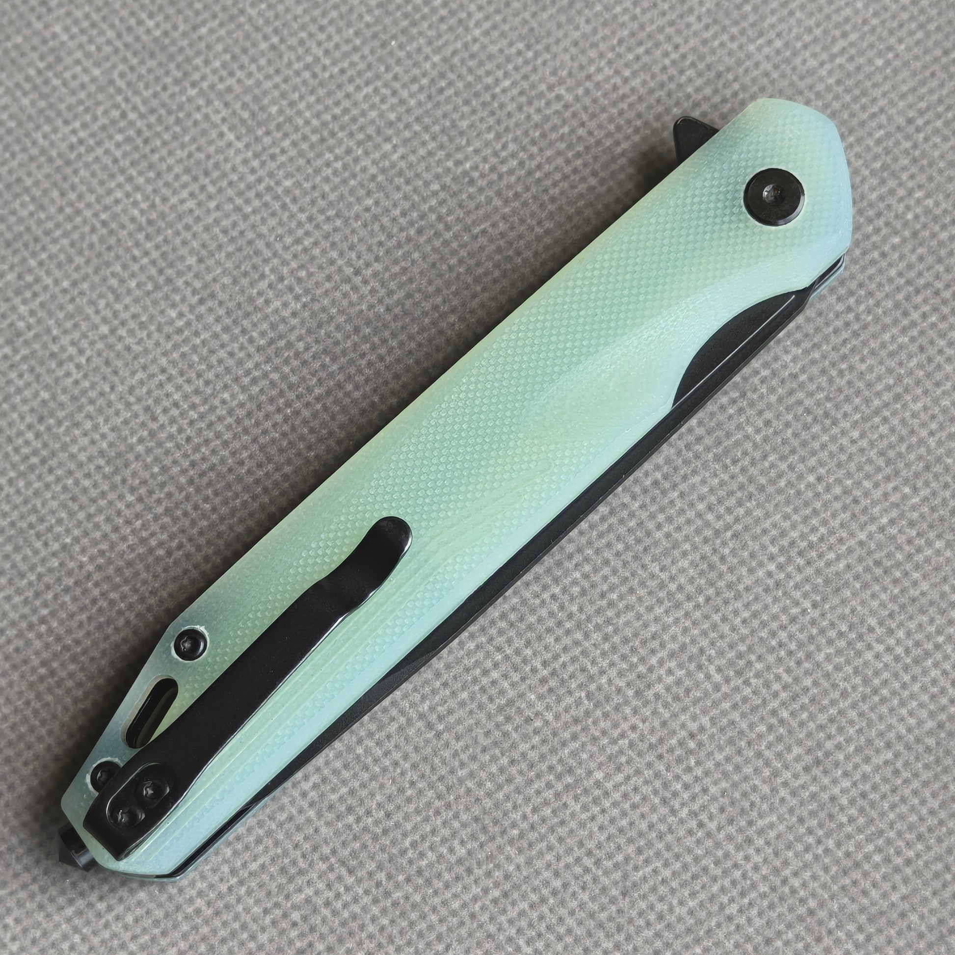 VORIXN KM005 closed clip-side view with pocket clip, screws, and carbon fiber handle back.